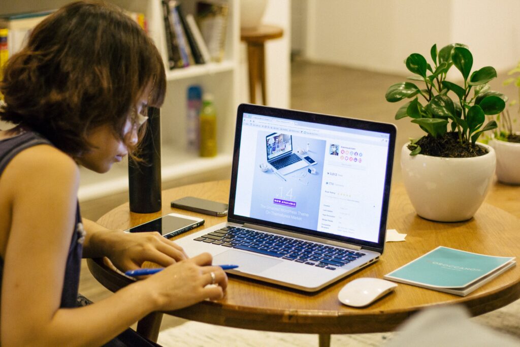 woman writing notes by computer