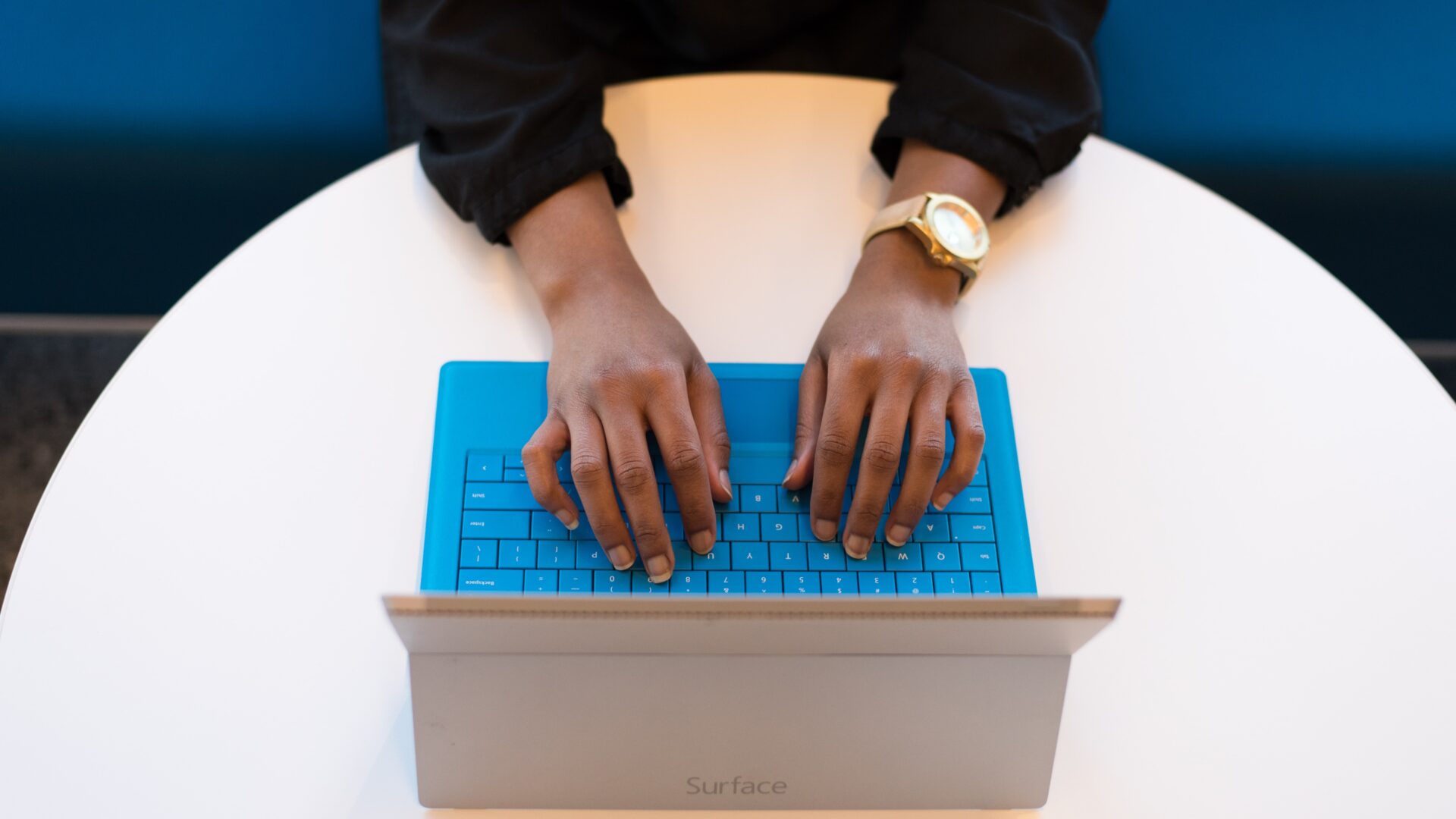 hands on blue laptop keyboard